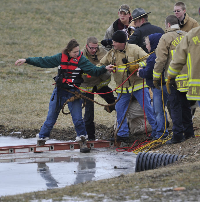 Spot News - 3rd placeA woman is rescued from the ice covered pond in her backyard at Pleasant Township after she stretched a ladder onto the ice and climbed out on it to rescue her dog that had fallen through the ice in the center of the pond. The dog was not able to be saved but fire fighters did recover the pets body from the water with a rescue boat. (Bill Lackey / Springfield News-Sun)