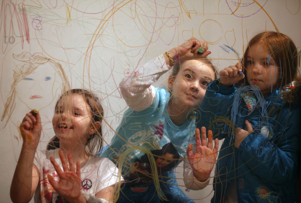 Feature - 1st place(From left) Elizabeth Williams, Angelina Williams and Juliet Haskett draw faces on glass with dry erase crayons in the Making Faces exhibit at the Columbus Museum of Art. (Thomas Levinson / The Columbus Dispatch)