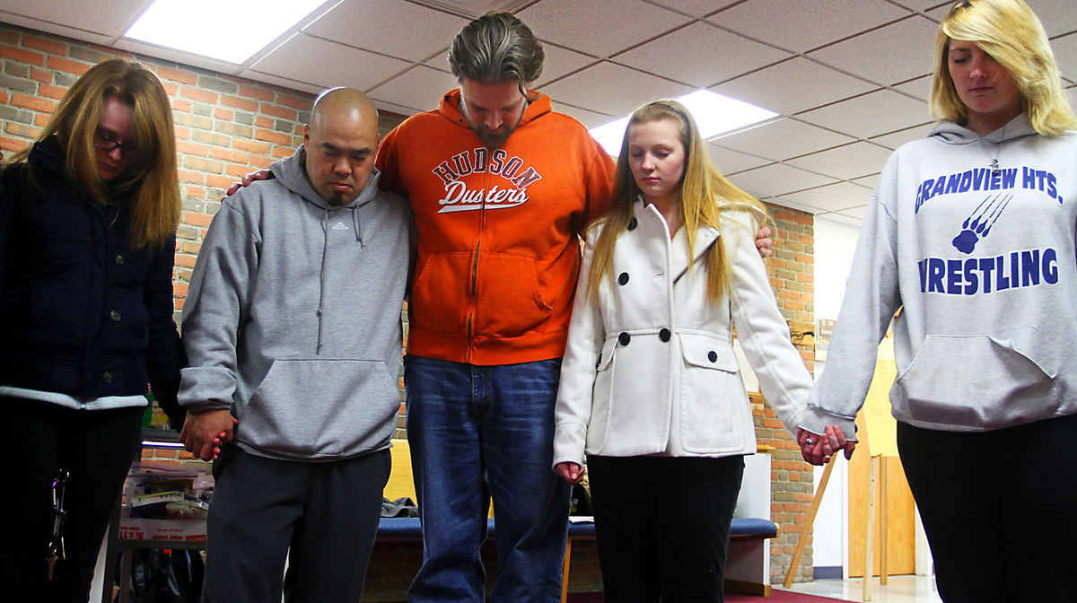 General News - 2nd placeMembers of the Reynoldsburg United Methodist's Fusion Youth Ministries hold hands during a prayer circle prior to leaving for New Jersey to help the local Habitat for Humanity rebuild homes damaged by hurricane Sandy. (Lorrie Cecil / ThisWeek Newspapers)