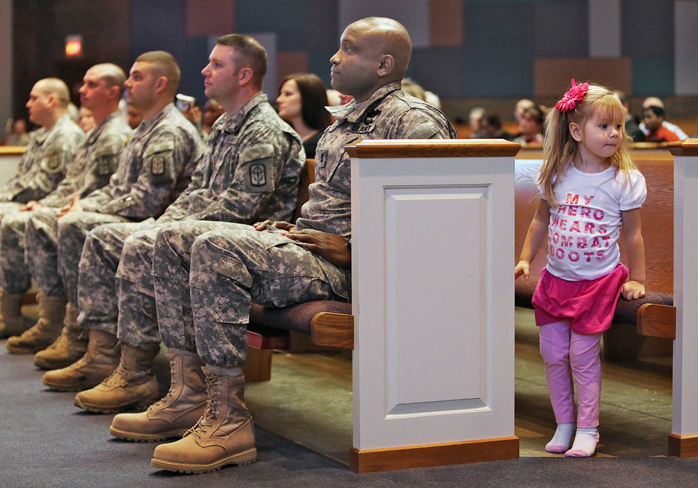 General News - 3rd placeOlivia Harkless, 2,  has a look around while members of the Ohio Army National Guards 174th Air Defense Artillery Brigade attend a call to duty ceremony at the Reynoldsburg United Methodist Church.  Her father, Staff Sgt Rudy Harkless is deploying in support of Operation Enduring Freedom.  Her shirt reads "My Hero Wears Combat Boots" .  (Chris Russell / The Columbus Dispatch)