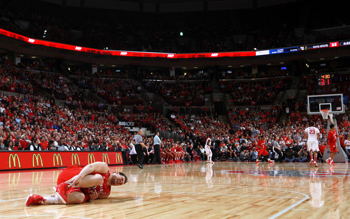 Sports Feature - HMThe game continues at the other end of the court as injured Nebraska Cornhuskers center Andre Almeida (32) holds his right ankle in pain during the first half of an a men's NCAA basketball game between Ohio State University and the Nebraska Cornhuskers at Value City Arena. Almeida left the game after play stopped and didn't return.  (Fred Squillante / The Columbus Dispatch)