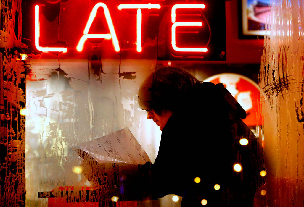 Feature - 2nd place - Sitting inside a warm D. P. Dough, on a freezing night, new employee Paul Porter of Columbus studies training manuals behind frost-covered windows. The time and temperature sign at Ohio State said it was -4 degrees outside when this photo was taken.  (Fred Squillante / The Columbus Dispatch)