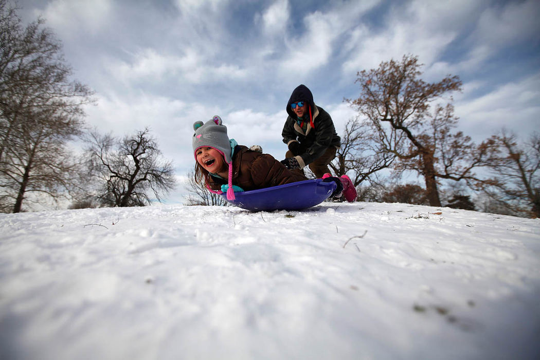 Feature - HM - Vanessa Lacich, 6, of Columbus, sleds down a hill after a push from her father Dom Joshua Lacich, at Schiller Park in the German Village neighborhood of Columbus.  (Sam Greene / The Columbus Dispatch)