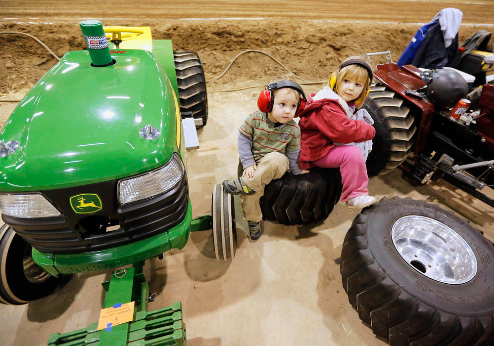 General News - 1st place - Landon Fuel, 2, and Hannah Fuel, 4, of Greensburg, Indiana, wait on large tires during a lull in the action while attending the Hilliard Tractor Club's 35th Annual Columbus Winter Championship Pull at the Ohio Expo Center. The event,  which is billed as the largest garden tractor pull in the nation, features over 500 competitors. (Barbara J. Perenic / The Columbus Dispatch)