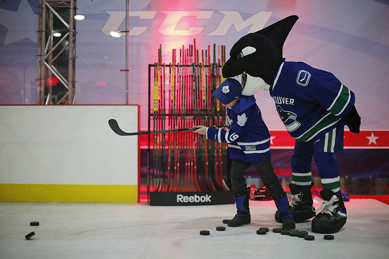 Sports Feature - 2nd place - Liam Coe, 9, of Cochrane, Ontario, gets attacked by Fin the Whale, the mascot of the Vancouver Canucks, as he tries an accuracy game during the NHL All-Star Fan Fair at the Greater Columbus Convention Center. (Eamon Queeney / The Columbus Dispatch)