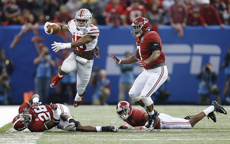 Sports - 3rd place - Ohio State running back Ezekiel Elliott (15) leaps over Alabama defensive back Landon Collins (26) on his way to a 54-yard run in the first quarter of the Sugar Bowl at Mercedes-Benz Superdome in New Orleans. (Eamon Queeney / The Columbus Dispatch)