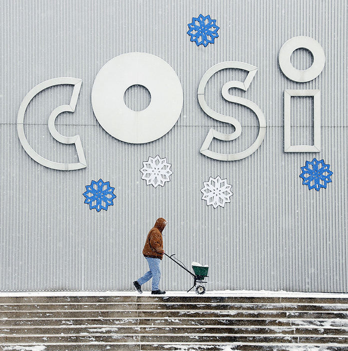 Feature - 3rd place - A maintenance worker spreads salt along the sidewalk in from of COSI as snow fell on Columbus on January 12.  (Barbara J. Perenic / The Columbus Dispatch)