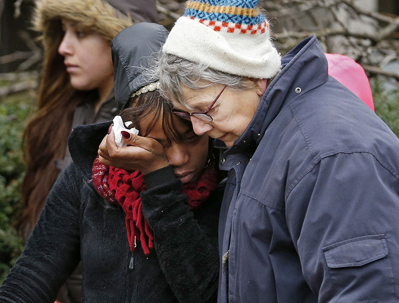 General News - 3rd place - Mia Taylor, (left) first cousin to victim Erveena Hammons, is comforted by Chris Rudin (right) at the site of a growing memorial to the slain Hammonds and her daughters Anaesia Green (10), and Breya Hammonds (7) who were murdered at their Continent Village apartment by Wendell L. Callahan, an ex-boyfriend who had been released early from federal prison in 2014.  (Barbara J. Perenic / The Columbus Dispatch)