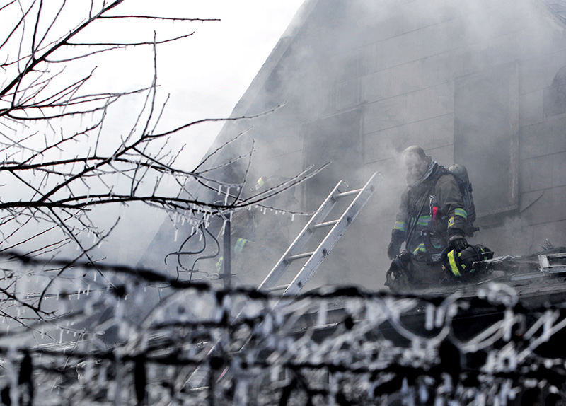 Spot News - 2nd place - A firefighters takes a breather after battling a house fire in Franklinton. The fire in the duplex was fatal for two occupants.It also displaced several neighbors due to heavy smoke conditions from the older home. (Eric Albrecht / The Columbus Dispatch)