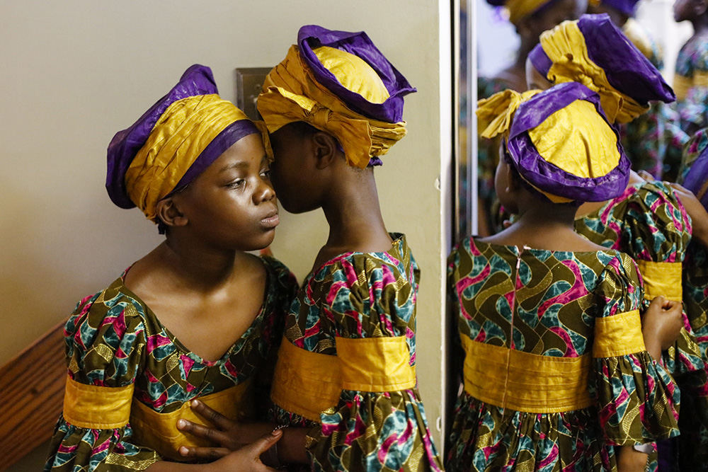 MTFeature - 1st place - Girls in the African Children's Choir wait in a hallway outside the sanctuary before performing at Karl Road Baptist Church in Columbus.  (Joshua A. Bickel / The Columbus Dispatch)