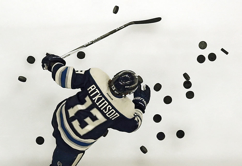 SSports Feature - 3rd place - Columbus Blue Jackets right wing Cam Atkinson (13) hits pucks onto the ice for warm-ups prior to the team's game against the Ottawa Senators at Nationwide Arena in Columbus. (Adam Cairns / The Columbus Dispatch)