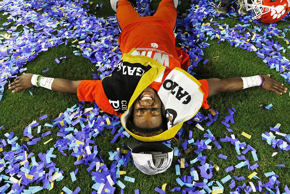 Sports Feature - HM - Clemson Tigers defensive back K'Von Wallace (12) makes a snow angel in the confetti during the First Bowl post-game celebration after the Tigers 31-0 win over Ohio State. (Barbara J. Perenic / The Columbus Dispatch)