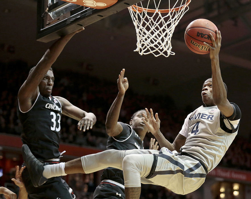 ASports - 1st place - Xavier Musketeers guard Edmond Sumner (4) is upended on his way to the basket in the second half of the 84th annual Crosstown Shootout game against the Cincinnati Bearcats at UC's Fifth Third Arena in Cincinnati. The Bearcats overcame a 44-36 halftime deficit to win 86-78. (Sam Greene / Cincinnati Enquirer)