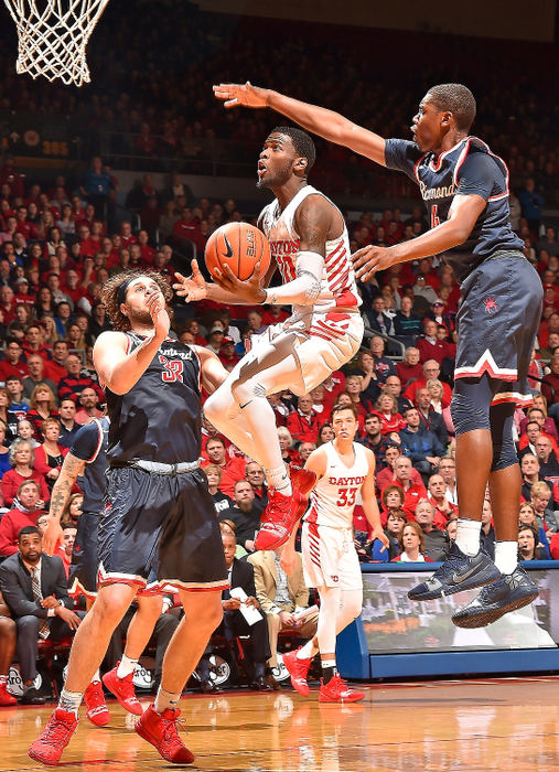 Sports - HMDayton's Jalen Crutcher swoops to the hoop between two Richmond defenders. Dayton defeated Richmond 72-48 at UD Arena.  (Erik Schelkun/Elsestar Images)