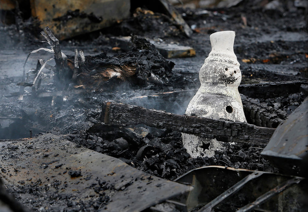 Spot News - 2nd placeA figurine of a snowman is surrounded  by smoldering ashes at the scene of a fatal fire at a mobile home in the 300 block of North State Street in New Lexington that claimed the lives of a 7-year-old girl and a 3-year-old boy. (Eric Albrecht/The Columbus Dispatch)