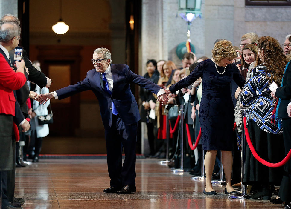 Story - 1st placeGovernor Mike DeWine tries to shake hands as his wife, Fran hugs a guest before the swearing in ceremony at the Statehouse rotunda on January 14, 2019. (Kyle Robertson/The Columbus Dispatch)