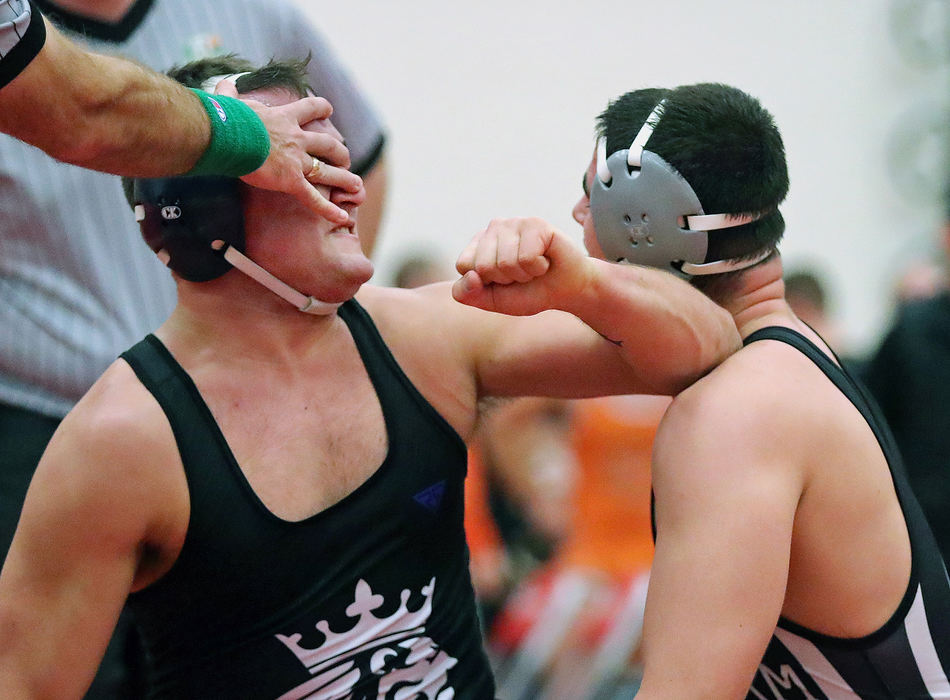 Sports Feature - 3rd place - Breslin Walker of CVCAs (left) blindly throws an elbow striking his opponent Nolan Neves of Graham as a referee attempts to break up the fight in the middle of the 220 pound championship match during the Grizzly Invitational wrestling tournament at Wadsworth High School. Walker was disqualified from the tournament after the incident. (Jeff Lange/Akron Beacon Journal)