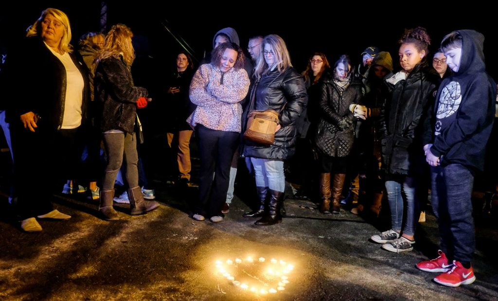 Spot News - 2nd place - Ravin Pinkelton (center) cries after arranging candles in the shape of a heart as police investigate a vacant house on East Fifth Street as part of the search for Harley Dilly in Port Clinton.  The body of 14-year-old Harley Dilly was found stuck in the chimney of the unoccupied house.  (Jeremy Wadsworth/The Blade)