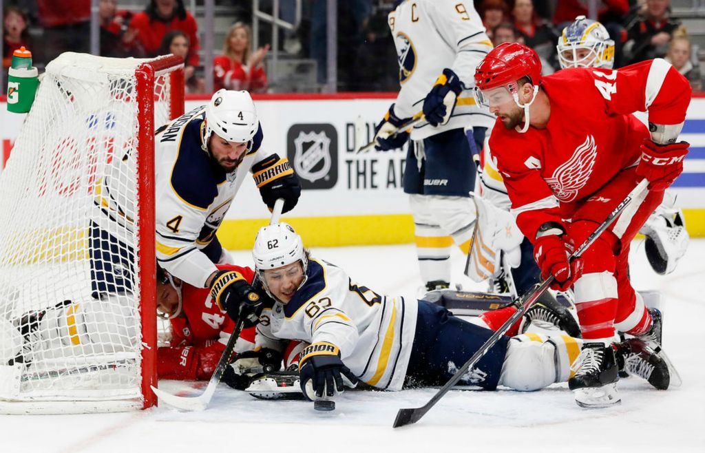 Sports - HM - Buffalo Sabres defenseman Brandon Montour (62) reaches for the puck infinite Detroit Red Wings center Luke Glendening (41) in the second period at Little Caesars Arena. (Rick Osentoski/Freelance)