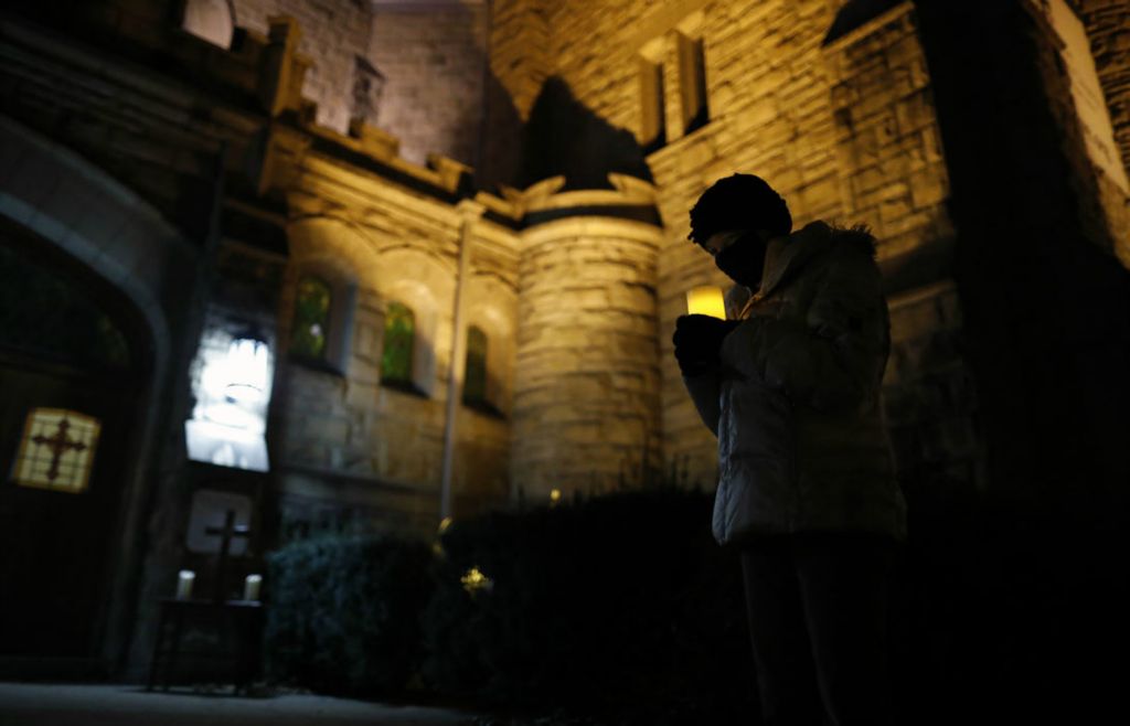 General News - 2nd place - Laura Dachenbach prays during a candlelight prayer service at King Avenue Church in Columbus. On the eve of Inauguration Day, a small gathering prayed for the peaceful transition of power and the healing of a divided nation.  (Kyle Robertson / The Columbus Dispatch)