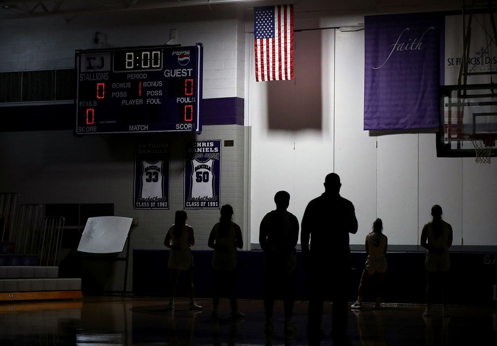 Sports Feature - 2nd place - Coaches and players with the DeSales girls basketball team stand before the American flag during the playing of the national anthem before a game against Thomas Worthington at St. Francis DeSales High School in Columbus. (Shane Flanigan / ThisWeek Community News)