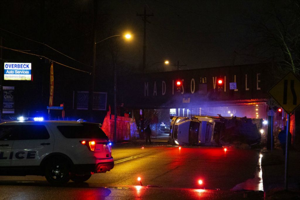 Spot News - 1st place - Police block off a section of Madison Road for a flipped truck, which struck the under side of the railroad bridge in the Madisonville neighborhood of Cincinnati. The low-hanging railroad bridge is known to the neighborhood as "The Can Opener" for its reputation of tearing the top off of semi trucks passing underneath.  (Sam Greene / The Cincinnati Enquirer)