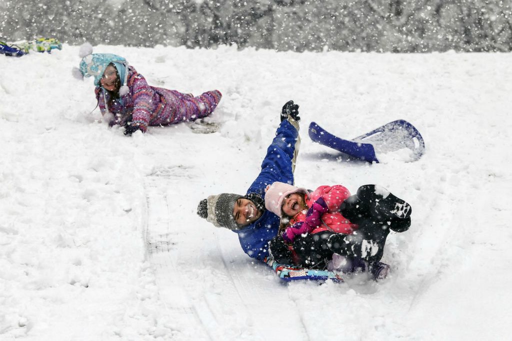 Feature - 1st place - Richard Bensman sleds with his daughters, Paige, 5, and Cora, 10, (top left) at Ottawa Park in Toledo.   (Jeremy Wadsworth / The Blade)