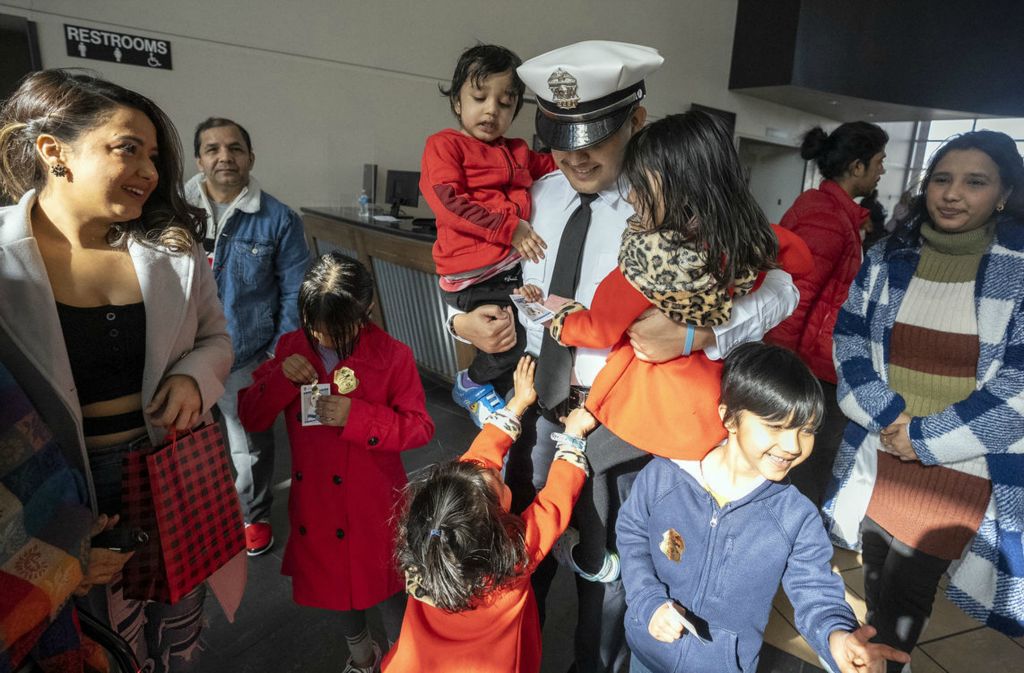 General News - 1st place - Newly sworn in Columbus Police Officer Prakash Poudyel is swarmed by his nieces, nephews and other family members following the James G. Jackson Columbus Police Academy graduation ceremony. Poudyel is the first in his Nepali family to be an officer.  (Brooke LaValley / The Columbus Dispatch)