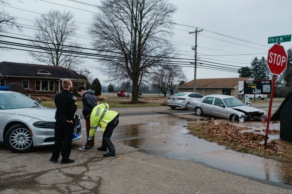 Spot News - 2nd place - A motorist is placed under arrest by an Ohio State Highway Patrol trooper after crashing into a fire hydrant at 1637 E High Ave. and 17th Street NE,  in New Philadelphia. Several reports from other motorists were taken by central dispatch for a reckless driver matching the description of the crashed car. (Andrew Dolph / The Times Reporter)