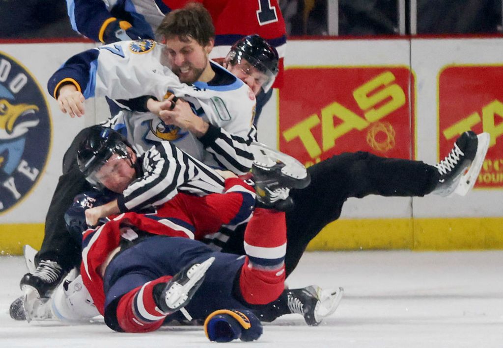 Sports - 2nd place - Two referees fall to the ice trying to break up a fight between Toledo’s Sam Craggs and Kalamazoo’s Justin Murray during an ECHL hockey game at the Huntington Center in Toledo. (Kurt Steiss / The Blade)