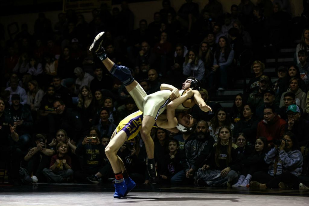 Sports - HM - Waite Indians wrestler Phoenix Contos (bottom)  throws Perrysburg Yellow Jackets wrestler Ryan Avalos to gain an advantage for a takedown in a winning effort during the 126-pound championship match of the Perrysburg Invitational Wrestling tournament at Perrysburg High School.  (Isaac Ritchey / The Blade)