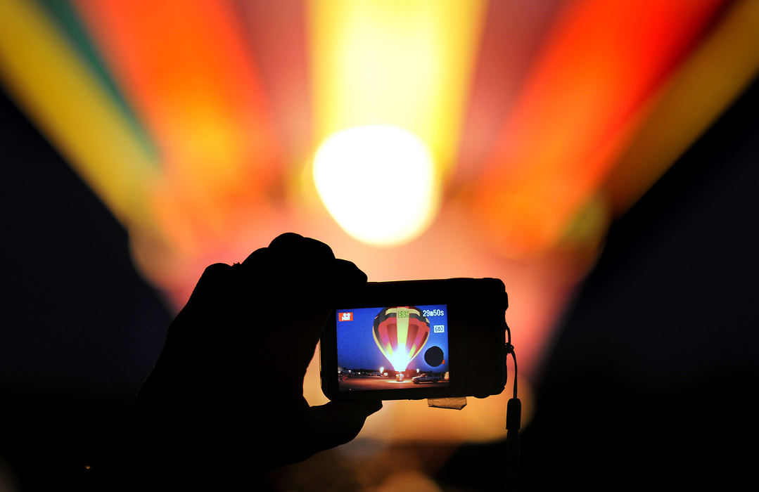 Feature - 2nd place - A hot air balloon, inflating for the balloon glow at the annual Champaign County Balloon Fest in Urbana is recorded on the back of a spectators camera as she holds it up to take a picture. (Bill Lackey / Springfield News-Sun)