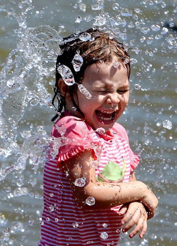 Feature - 3rd place - Nora Baker, of Ohio City, screams with delight as her father, Sam Baker, yells "Tidal Wave!" and sprays water at her at Rocky River Park. (Lisa DeJong / The Plain Dealer)