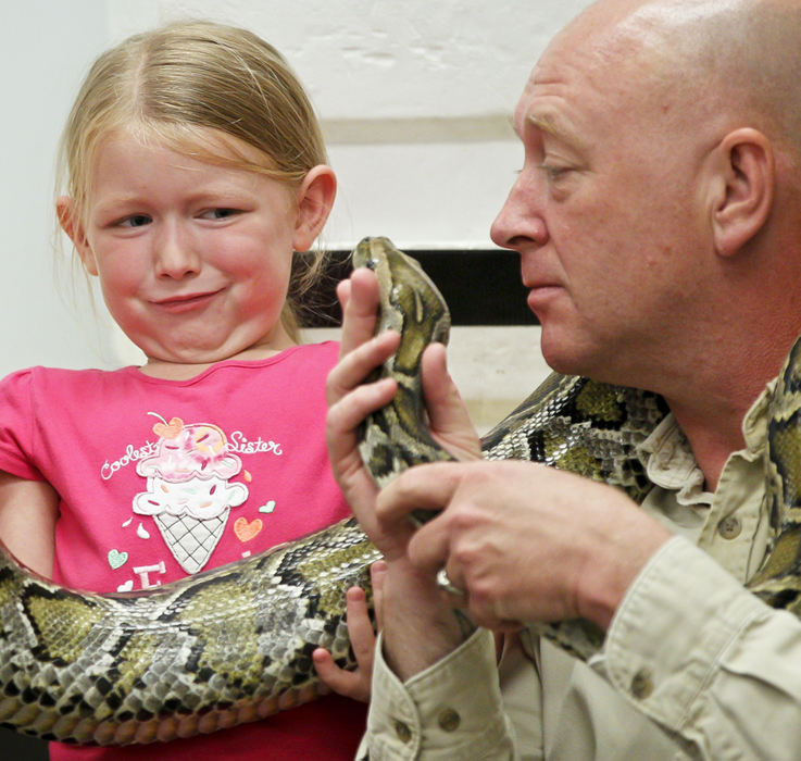 Feature - 3rd placeBreelyn Neil, 5, flinches as Peter Rushton presents her with a Burmese python during the P.T. Reptiles show at the Park Branch of the Public Library as part of the Summer Reading Program (Barbara J. Perenic / Springfield News-Sun)