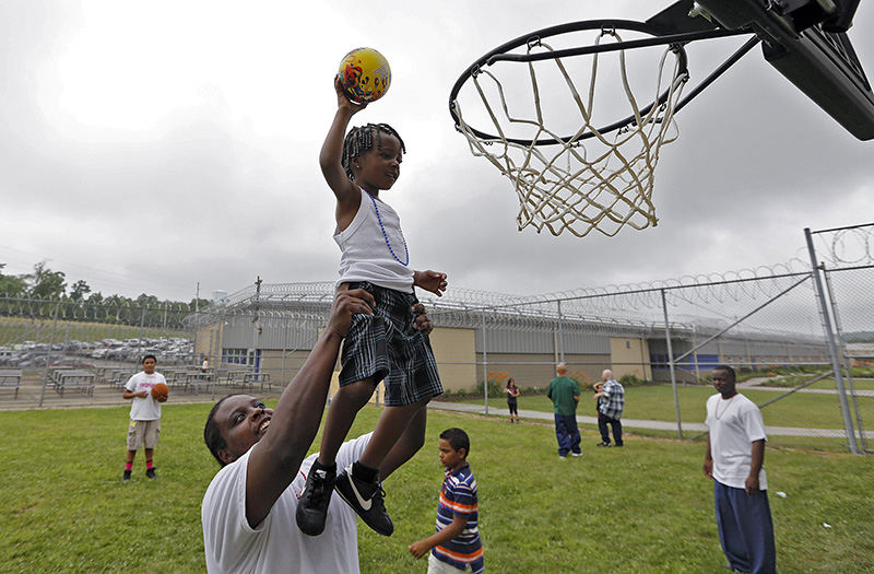 General News - 2nd place - Brandon Jackson helps his son Braelyn, 4, dunk the basketball during the "Fathers Matter Day" at the Belmont Correctional Institution in St. Clairsville. (Kyle Robertson / The Columbus Dispatch)