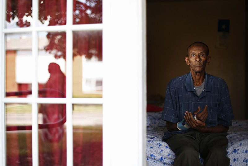 Portrait - 1st place - Elmi Nur, 65, sits on his bed and holds his damaged right arm as he poses for a photograph in his Capital Park Apartment in Northeast Columbus. Nur was attacked and beaten steps from his home about two months ago by a group of four men from outside of the neighborhood. The police were notified but no one was apprehended. The apartment complex is home to a large population of Somalis but recently many Somalis have been preyed upon by outsiders.  (Eamon Queeney / The Columbus Dispatch)