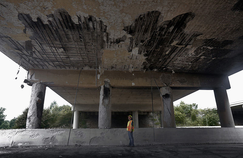 General News - HM - Mitch Blackford ODOT District 6 Highway Management Administrator looking at  the underside of the eastbound I-70 bridge that was burnt out following a tanker fire. (Tom Dodge / The Columbus Dispatch)