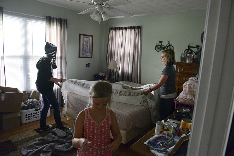 Story - 1st place - Stephanie's daughters, Emma, 12, and Lily, 8, help their mother with chores around the house. The girls matured quickly to be able to care for Stephanie after she returned home from inpatient rehabilitation. They took on many household responsibilities and helped Stephanie move about until she could do it on her own. (Shane Flanigan / Zanesville Times Recorder)