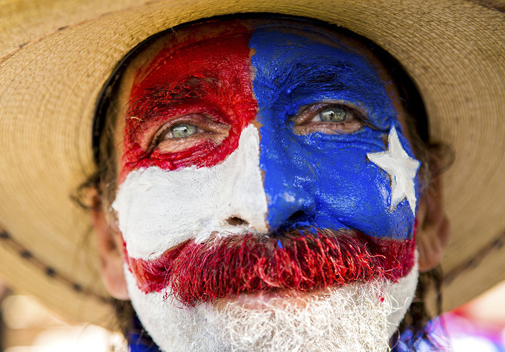 Portrait - 2nd place - Marcos Spence of Dallas, Texas,  poses for a portrait at Settlers Landing in Cleveland on the first day of the Republican National Convention. Spence travels around the country to attend Trump events.   (Meg Vogel / Cincinnati Enquirer)