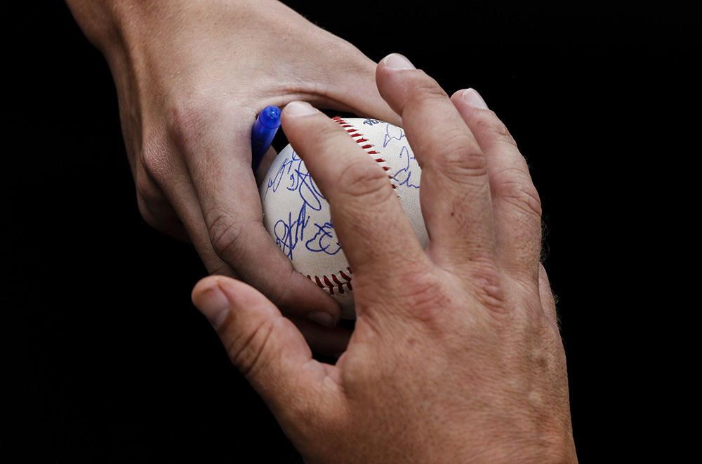 Sports Feature - 1st place - A fan has his ball autographed by Toledo Mud Hens players before the Hens play the Indianapolis Indians during their baseball game at Fifth Third Field. (Andy Morrison / The (Toledo) Blade)