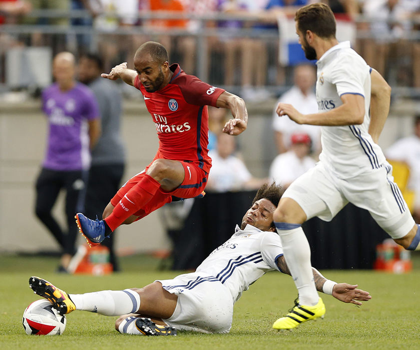 Sports - 3rd place - Real Madrid defender Marcelo (12) knocks the ball away from Paris Saint-Germain midfielder Lucas (7) during the 1st half at Ohio Stadium. The game was the first soccer game at Ohio Stadium since 1999.   (Kyle Robertson / The Columbus Dispatch)