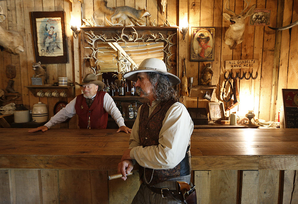 AStory - 2nd place - Inside the first building he built, Mike Montgomery (right) talks to Roy Miller inside the Dogwood Saloon at Dogwood Pass in Beaver, Ohio. The saloon was originally meant to be Montgomery's man cave, but it inspired the building of an entire Old West town.  (Adam Cairns / The Columbus Dispatch)