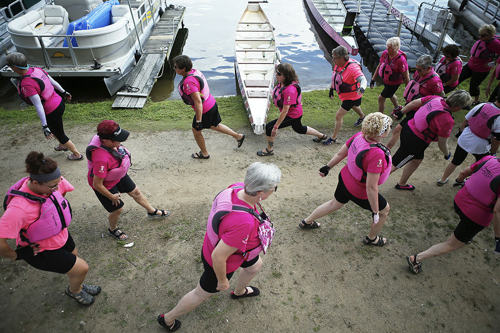 Sports Feature - 3rd place - The Dragon Dream Team stretches out before practice at Rex Lake in Akron. The team was preparing for the fifth annual Dragons on the Lake Dragon Boat Festival where more than 35 dragon boat teams will race on Rex Lake. The Dragon Dream Team, Ohio's only breast cancer-survivor dragon boat team, is using some of the funds to attempt its first international competition later this year. (Leah Klafczynski / Akron Beacon Journal)