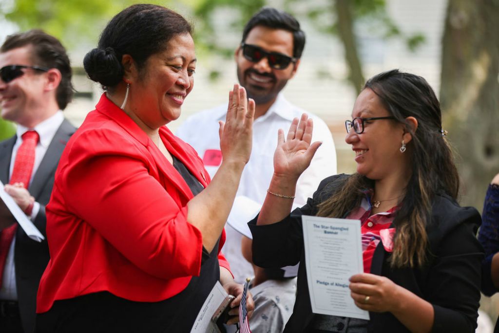 General News - 3rd place - Betty Lisi Mario (left) high fives Cecilia Mata after reciting the Oath of Citizenship during a Naturalization Ceremony at Sauder Village in Archbold. (Rebecca Benson / The Blade)  