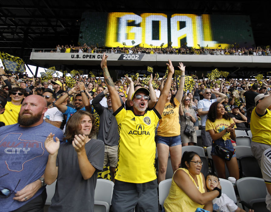 Sports Feature - 3rd place - Columbus Crew fan Christopher Klopfer (center) celebrates after the Crew's second goal against New England Revolution in their first MLS game at Lower.com Field in Columbus. (Kyle Robertson / The Columbus Dispatch)  