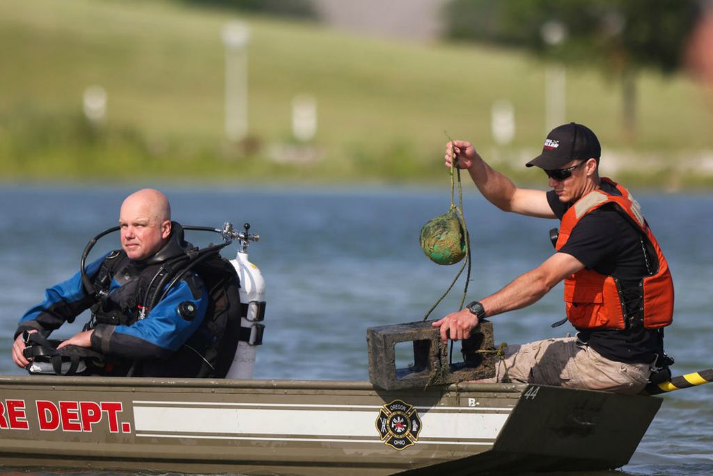 Spot News - 2nd place - The Oregon Fire Department water rescue team picks up a ball tied to a cinderblock after a swimmer reported touching something resembling a body while in the water in Inland Lake at Maumee Bay State Park in Oregon. (Rebecca Benson / The Blade)  