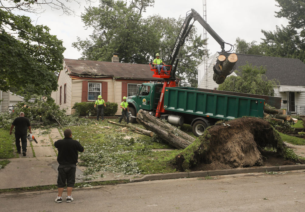 Spot News - 3rd place - James Hooks, Jr., operating the crane on the truck, lifts logs into a truck as he and others with the city forestry department clear a tree that fell and damaged a home at Wyndale Road in West Toledo. (Kurt Steiss / The Blade)  