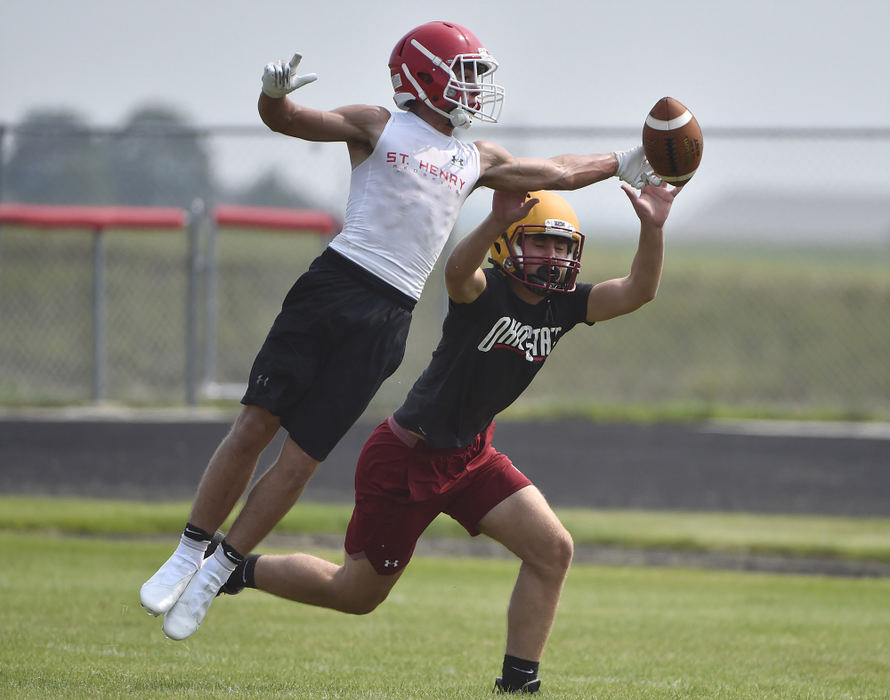 Story - 2nd place - St. Henry's Jaden Lange gets his finger tips on a pass in the end zone as New Bremen's Gavin Pleiman knocks it down during a 7-7 scrimmage at the Wally Post Athletic Complex in St. Henry (Daniel Melograna / The Daily Standard)  