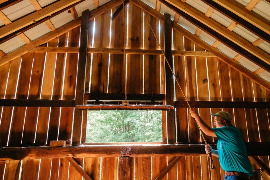 Feature - 2nd place - Michael Schmuki opens a window in his barn in Oxford Township. He said he has learned from experience how to manage the trees on the 238-acre farm, located on Starkey Hollow Road SW, about five miles south of Newcomerstown. The Schmuki’s were recently awarded  2023 Ohio Tree Farm of the Year. (Andrew Dolph / The Times Reporter)