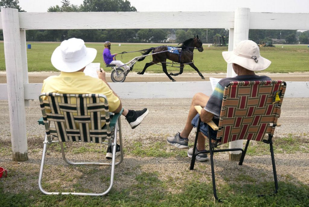 General News - 2nd place - Mike Williams and Tom Wood watch the harness races at the Franklin County Fair while they check their programs to log the winners.  (Brooke LaValley / The Columbus Dispatch)